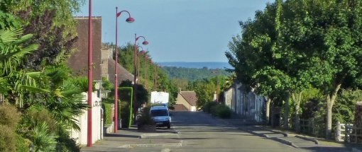 Neufchâtel-en-Saosnois, un bourg de lisière en promontoire sur le paysage alentour dont les rues cadrent des vues sur les cuestas boisées au sud (Neufchâtel-en-Saosnois) en grand format (nouvelle fenêtre)