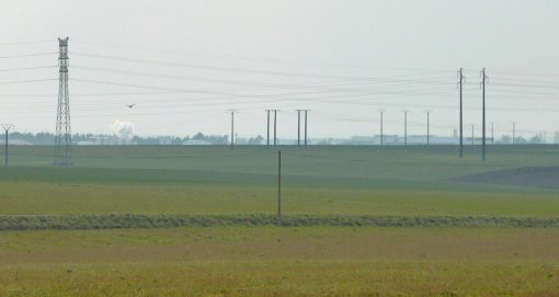 Vue vers le sud depuis la RD 745 (sortie est de Fontenay-le-Comte) : Les infrastructures liées au transport de l'électricité sont très visibles dans le cadre des paysages de champs ouverts en grand format (nouvelle fenêtre)